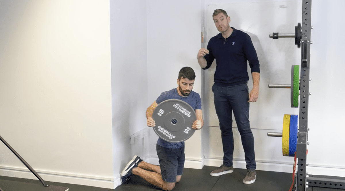 Overhead reach with plate eccentric hamstring exercise